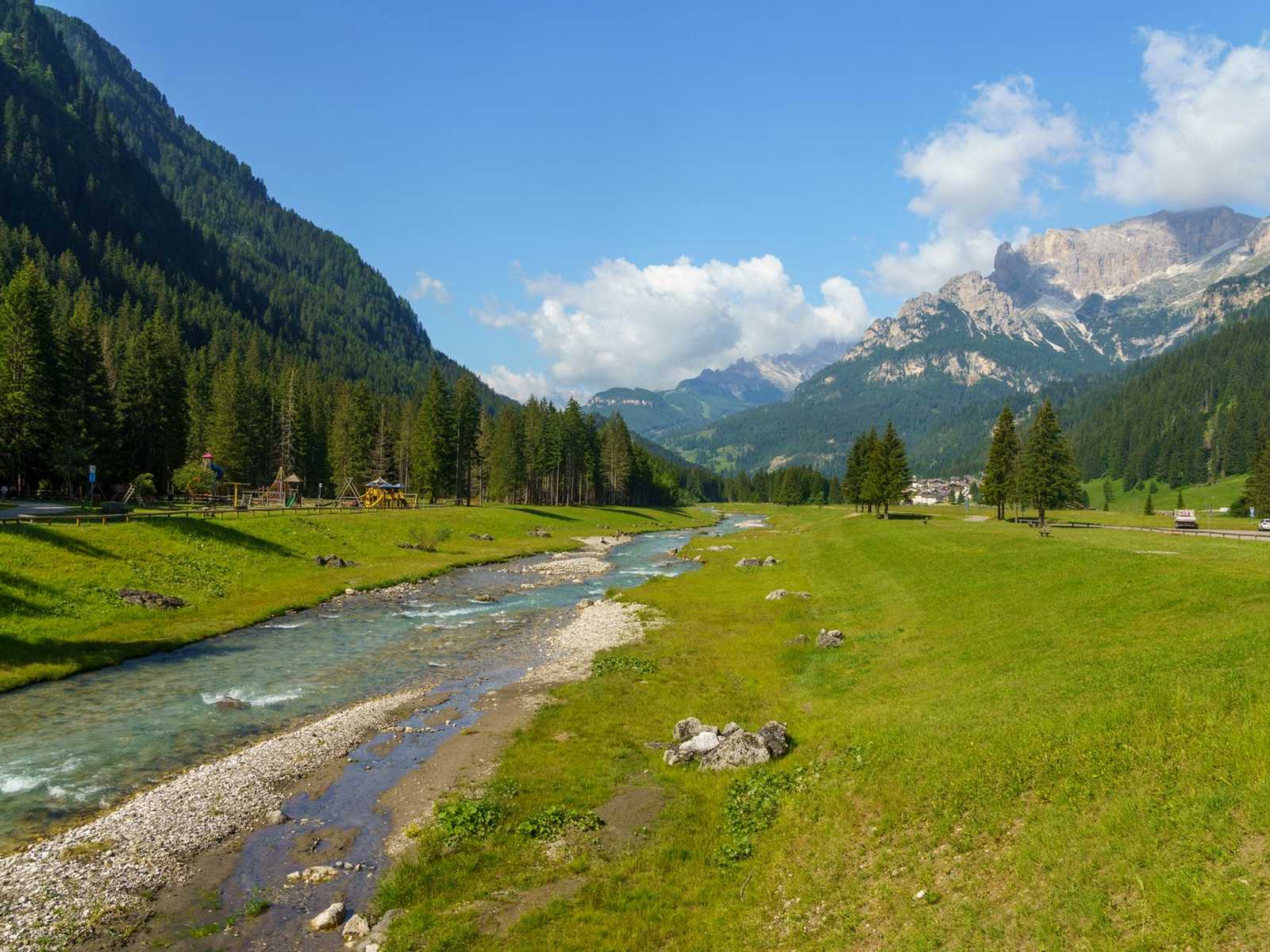 נוף נהר והרים ירוקים באזור מוענה (Moena) בדולומיטים