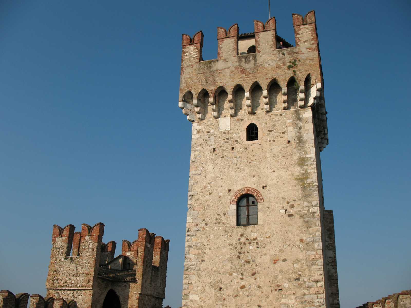 מגדל האבן העתיק של טירת סירמיונה על רקע שמיים כחולים באזור אגם גארדה