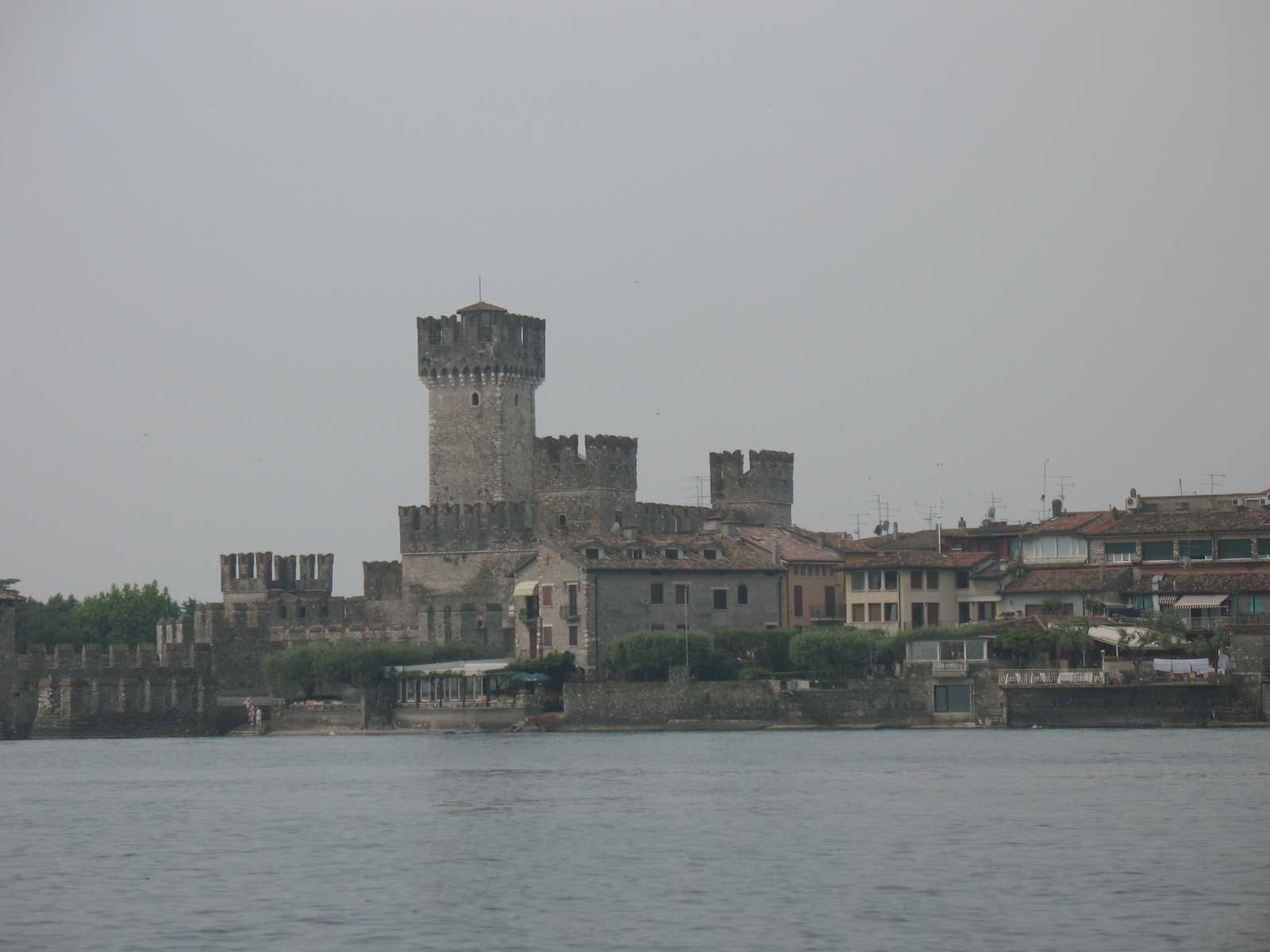 טירה על שפת המים ביום מעונן באגם גארדה