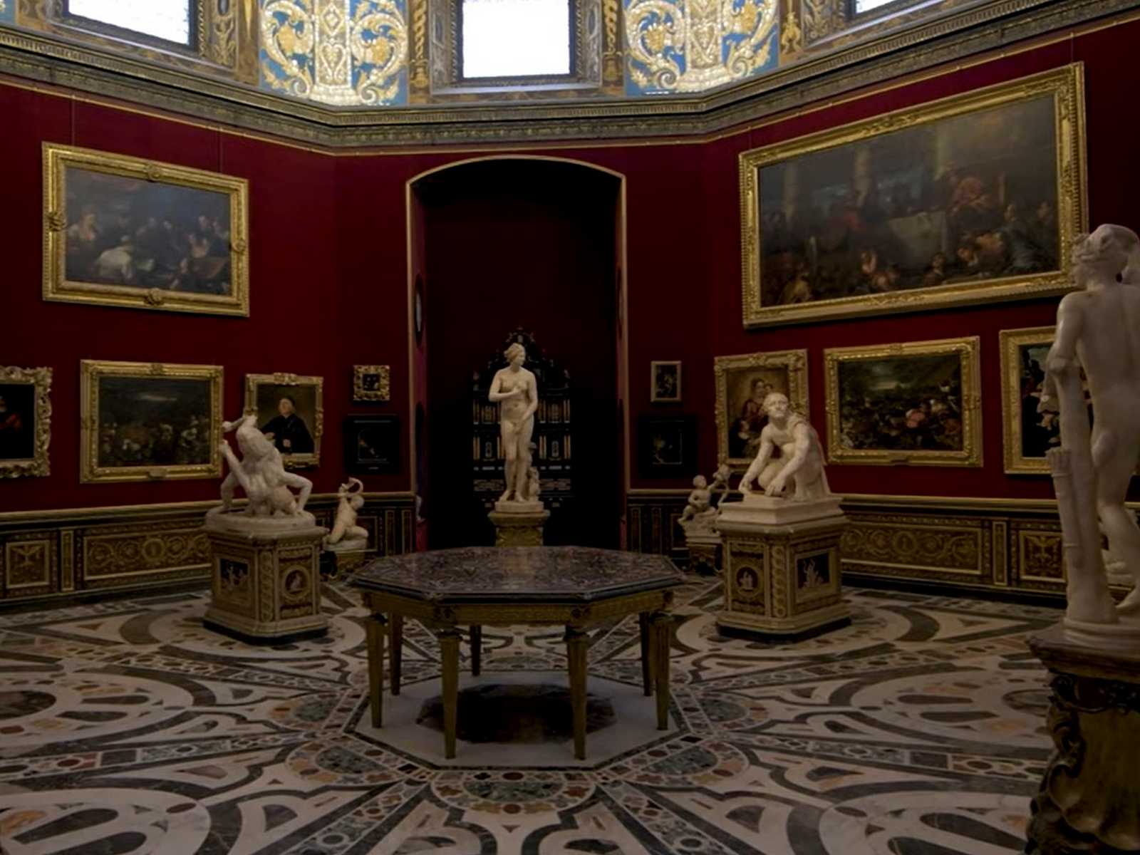 חדר תצוגה מפואר עם יצירות אמנות קלאסיות בתוך גלריית אופיצי בפירנצה