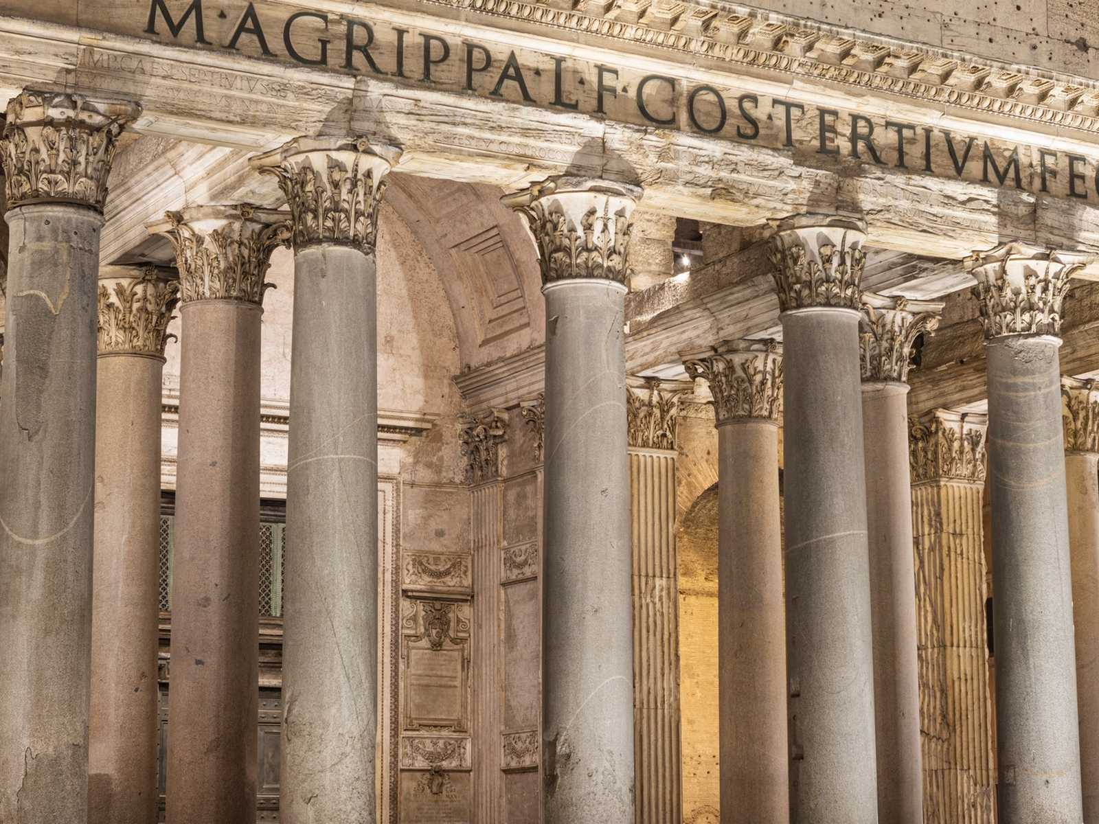 העמודים הקלאסיים של הכניסה אל הפנתיאון ברומא עם הכיתוב ההיסטורי מעליהם.