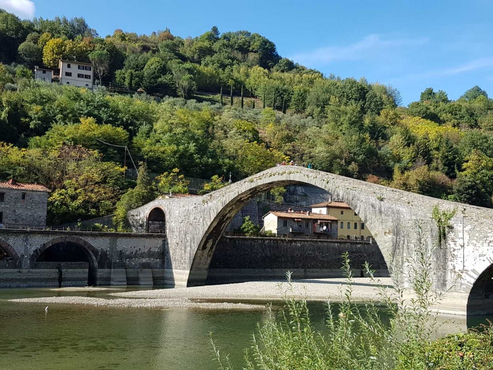 גשר פונטה דלה מדדלנה מעל נהר סרקיו בנוף ההררי של טוסקנה