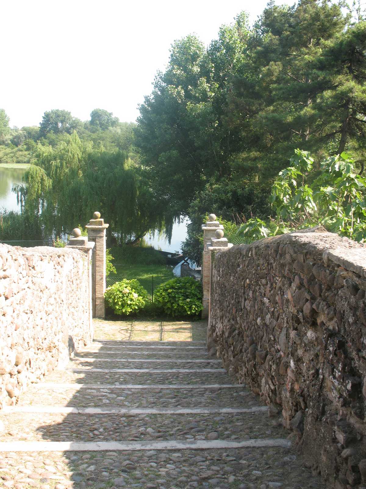 שביל אבן עם מדרגות בין עצים ובתים כפריים באחד הכפרים הציוריים של לומברדיה