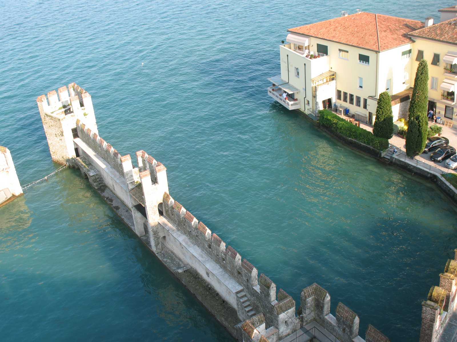 טיילת צרה מעל המים לצד מבנים צבעוניים על שפת האגם בלב לומברדיה