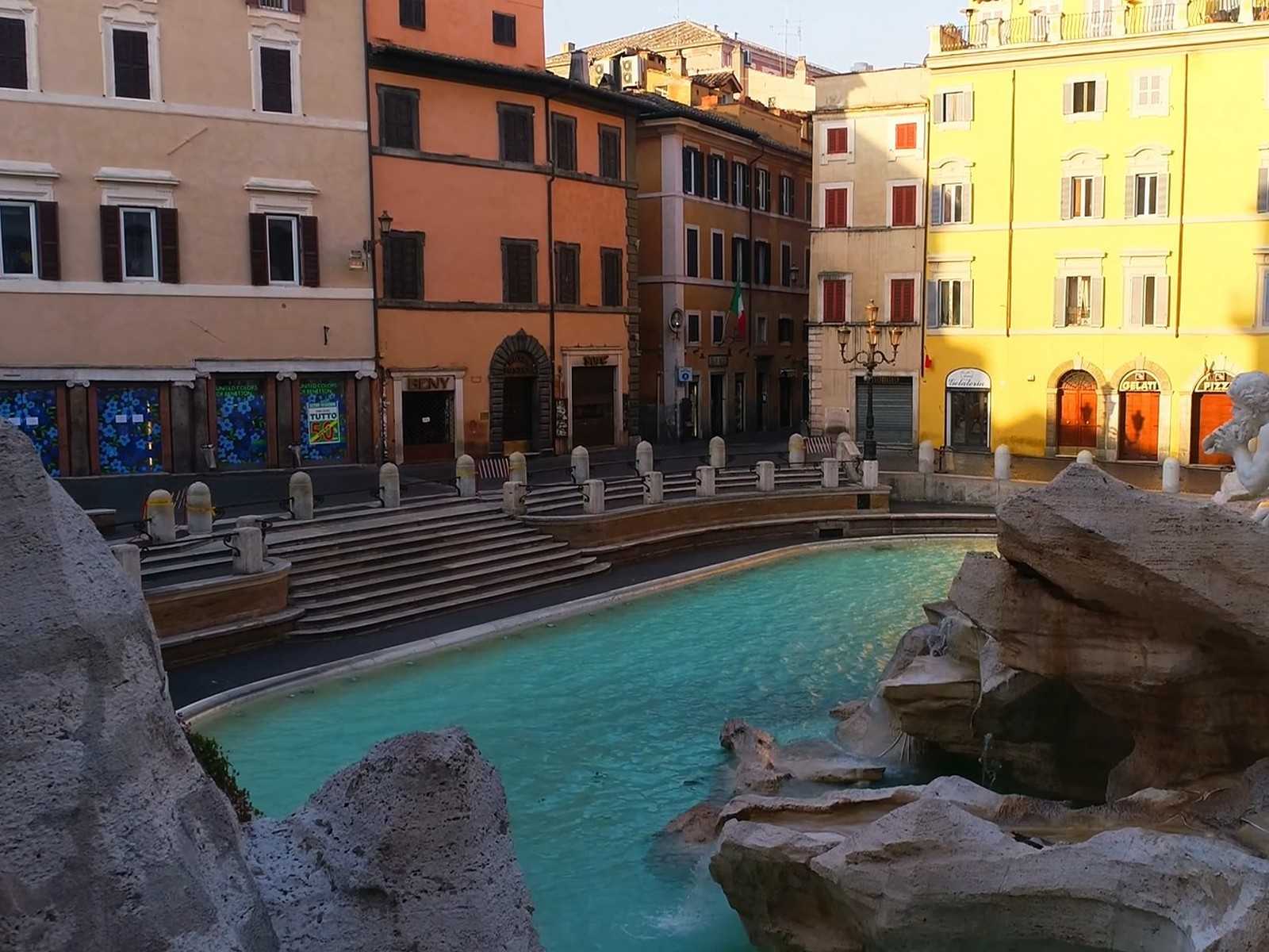 הכיכר הציורית סביב מזרקת טרווי עם המבנים ההיסטוריים והמבקרים הרבים.