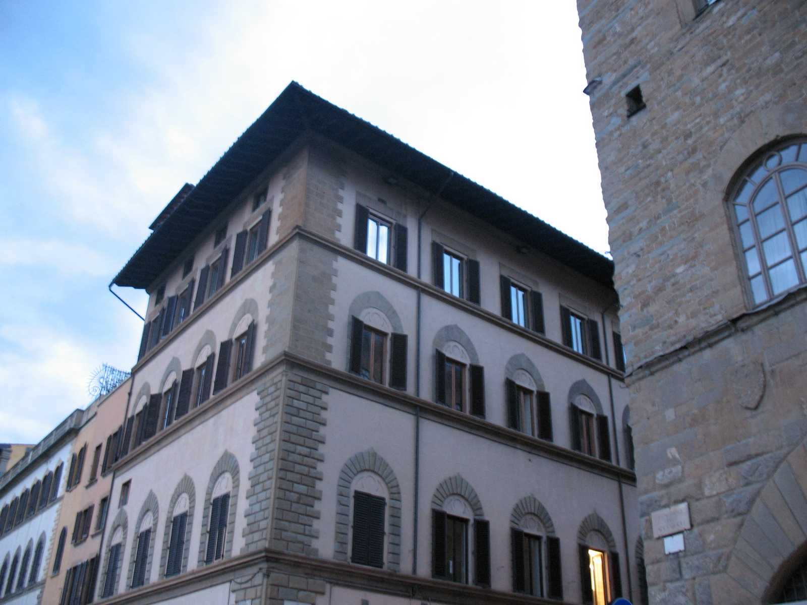 בניין היסטורי מתקופת הרנסנס במרכז פירנצה עם חלונות קשתיים ותריסים כהים