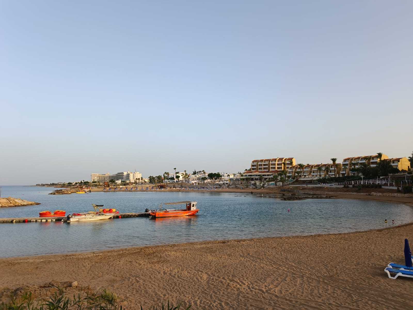 שקיעה בקו החוף של קלבריה: סירות קטנות על המים וחול זהוב במפרץ שקט.
