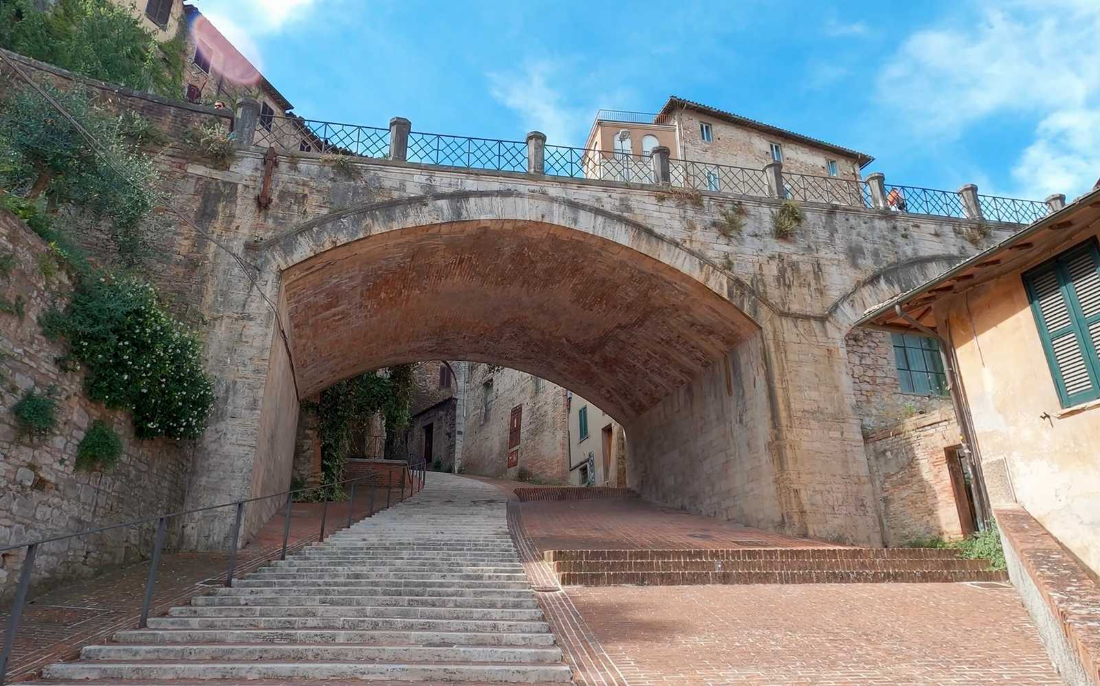 מדרגות אבן וגשר קשת בעיר העתיקה של פרוג'ה בין מבנים היסטוריים
